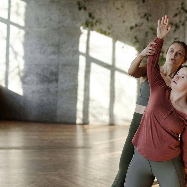 Person stretching gracefully in a bright, sunlit room.